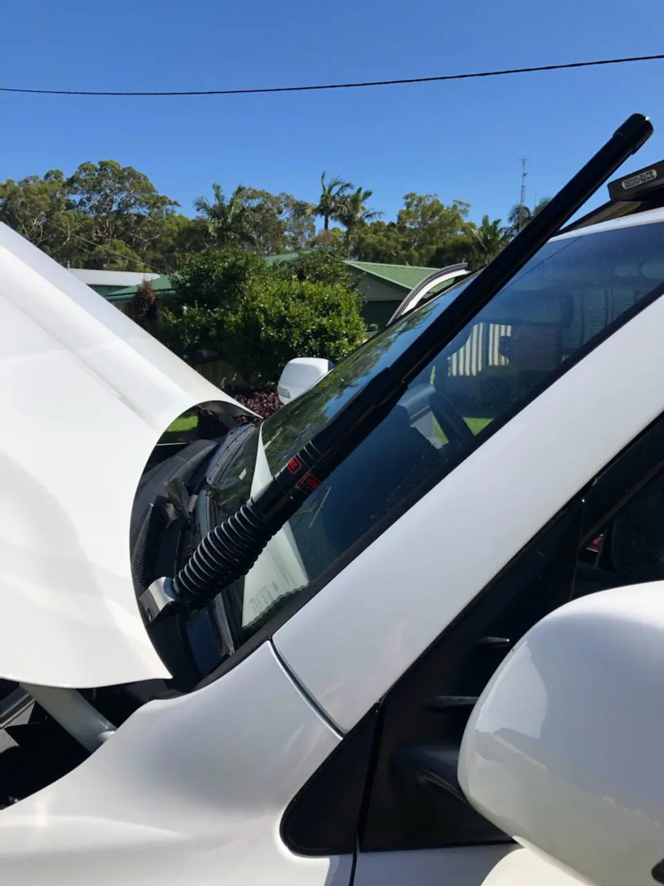Side view of a white car with a GMF4x4 bonnet hinge antenna mount