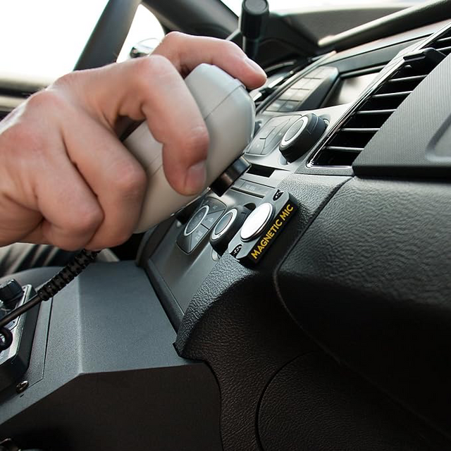 Person mounting a handpiece on a magnetic mic holder 