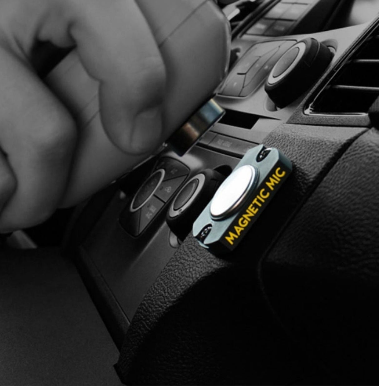 Low Light Image of a Hand Mounting a Microphone on a Magnetic Mic Holder