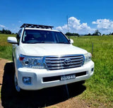 White Toyota Landcruiser standing on a grass field with a GMF4x4 bonnet hinge antenna mount installed